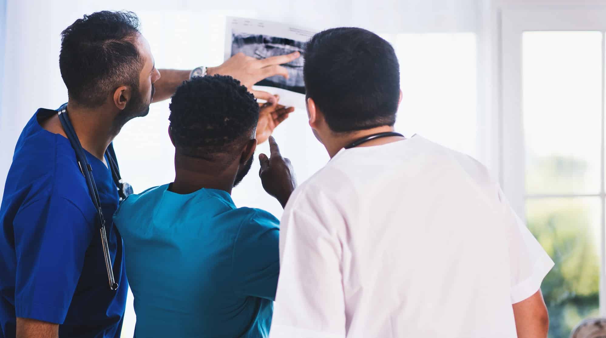 Understanding diversity - Nurse standing - men looking at x-ray